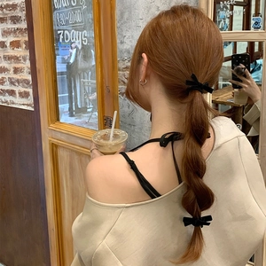 Elegant black velvet bow hair scrunchies set for women in a cozy cafe setting