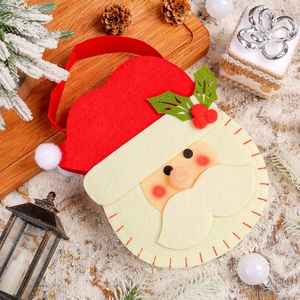 Christmas Santa felt gift bag on a warm holiday background with pine cones and snow