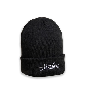 Detail of the white MEOW embroidery with cat ears on a black ribbed knit beanie hat