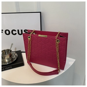 Detail of magenta rectangular tote bag featuring geometric hexagonal embossed pattern