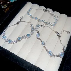 Silver bow bracelet with oval aquamarine zircon and heart accents on velvet display