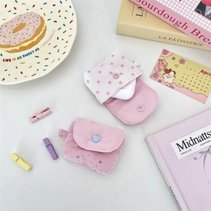 Close-up of pink star pattern fabric earphone cases with heart button and soft cotton texture