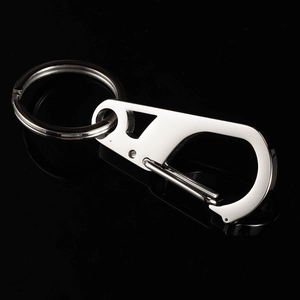 Close-up of a silver stainless steel carabiner keychain on a reflective black background