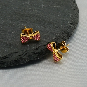 Vue macro détaillée des boucles d'oreilles nœud plaqué or 18K avec cristaux roses