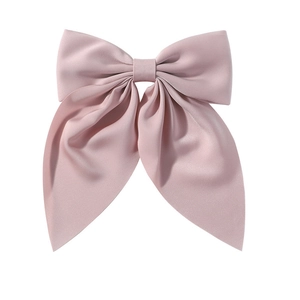 Detailed view of elegant pink oversized satin bow hair clip with flowing ribbon design