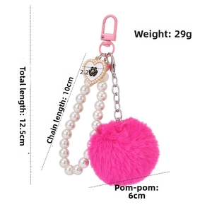 Porte-clés pompon rose avec chaîne de perles, breloque cœur et détails de dimensions
