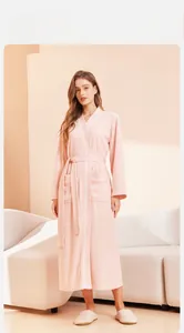 Pink long-sleeved bathrobe detail with large side pockets and matching indoor slippers