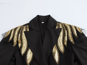 Detail of gold sequin and bead embroidery on black blazer shoulders with mesh panels