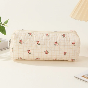 Detailed texture of quilted cotton pouch with small red floral and grid pattern
