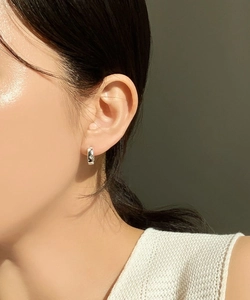 Close-up of a 925 sterling silver starburst hoop earring on a model for daily wear