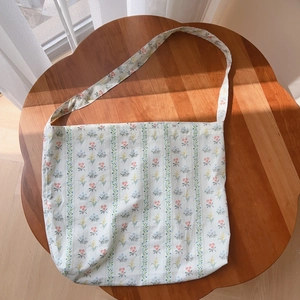 Detail of floral printed cotton tote bag with red and blue flowers on white fabric