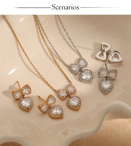 Detail of bow and heart jewelry set with clear zircon stones in gold and silver finish