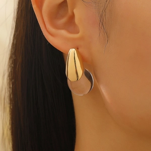 Close-up of minimalist resin teardrop earring in gold finish on a model ear