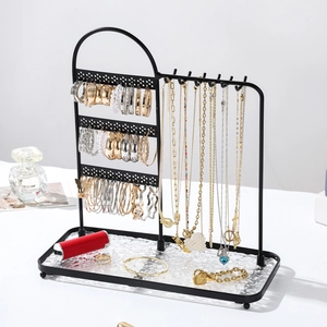 Black metal jewelry organizer with earring holes, necklace hooks and clear textured tray