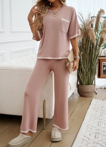 Détail de l'ensemble rose tricoté avec bordure blanche sur le col et le pantalon large