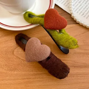 Acrylic wool heart hair clips set in green and brown on a rustic wooden table