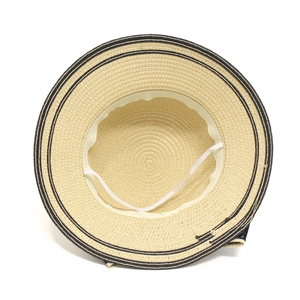 Internal detail of a beige straw hat with sweatband, wind rope and black stripe accents