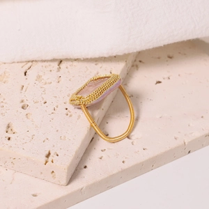 Baroque style gold wire-wrapped ring with a pink oval pearl on natural stone