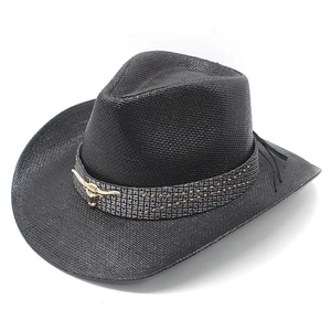 Close-up of golden bull head ornament and metallic studs on black straw cowboy hat