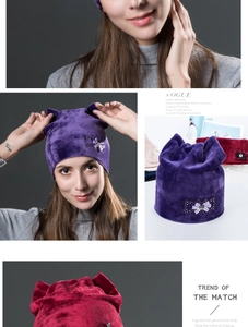 Close-up of velvet cat ear hat with rhinestone bow detail in purple and burgundy