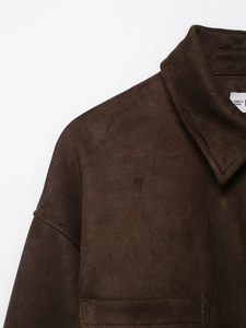 Gros plan détaillé montrant la texture en daim et la couture du col de la veste brune