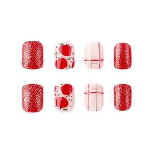 Detail of glossy Christmas fake nails featuring red glitter and apple patterns