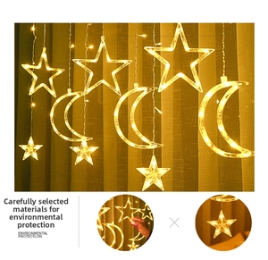 Detail of warm white LED curtain lights with star and moon shaped hanging ornaments