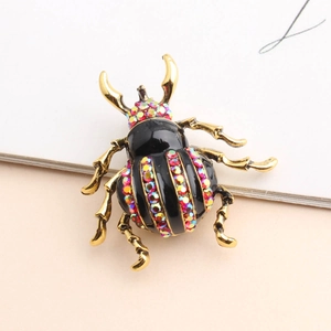 Macro view of beetle brooch showing gold plating and multicolor rhinestone inlay detail