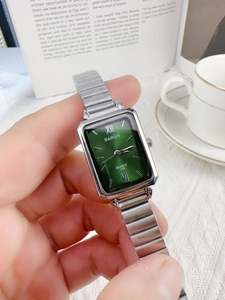 Close-up of a ladies' green square quartz watch with a silver metal bamboo link bracelet