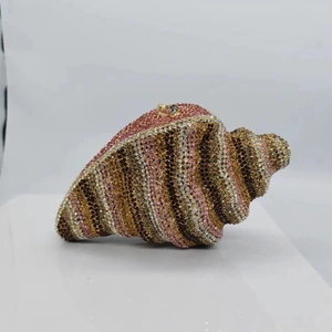 Detailed close-up of shell-shaped evening clutch bag featuring colorful striped rhinestones