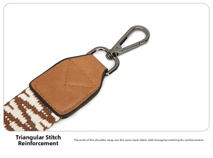 Detail of adjustable woven shoulder strap with reinforced triangular stitching for bag