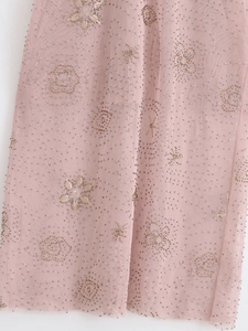 Detail shot of delicate pink mesh midi dress with intricate sequin and floral beadwork