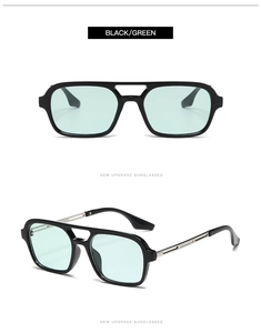 Detail of aviator sunglasses with black frames, light green lenses and silver metal temples