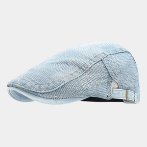 Detail of light blue flat cap with honeycomb weave texture and bronze metal side buckle