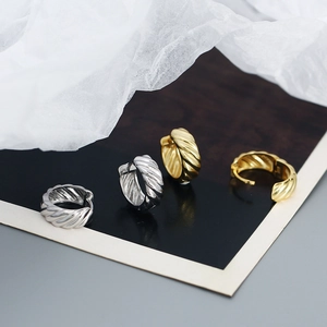 Macro shot of twisted silver and gold plated hoop earrings on minimalist card