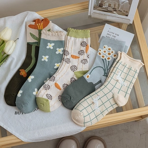 Flat lay of five pairs of cotton crew socks featuring floral and plaid patterns