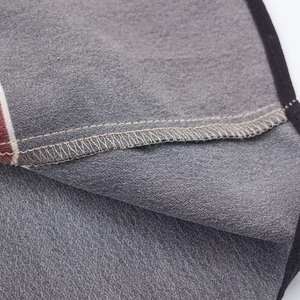 Detail view of grey printed fabric with black piping and reinforced stitching seams