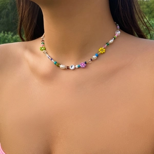 Close-up of handmade Y2K beaded choker with colorful flowers and white pearl detail