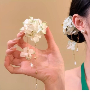 Close-up of elegant cloth petal hair clip featuring pearl tassels and gold chain