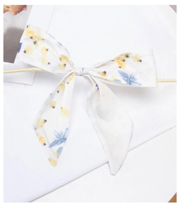 Detailed view of floral pattern bow headband with yellow flowers and blue leaves texture