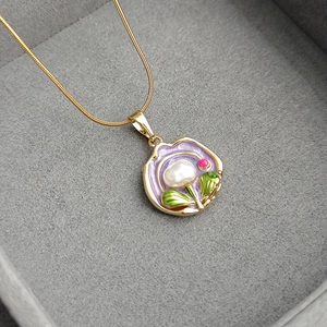 Vintage Monet garden pendant necklace with purple enamel and pearl on velvet display