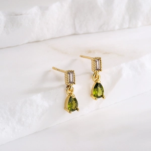 Gold-plated teardrop earrings with green and clear zircons on minimalist stone pedestals