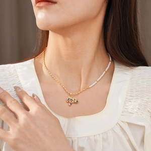 Detail of vintage horse necklace with mixed gold chain and white pearls for women