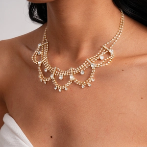 Close-up of golden fringe necklace with teardrop rhinestones on model for gala events