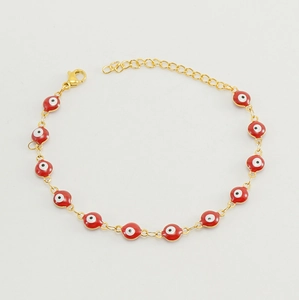 Detail of red enamel evil eye bead on gold-plated stainless steel chain bracelet