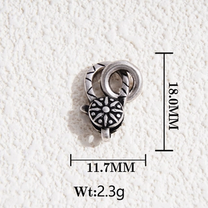 Macro view of vintage silver lobster clasp with carved sunflower and geometric patterns