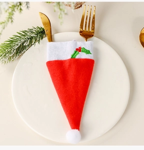 Detail view of a Santa hat cutlery holder with embroidery on a white ceramic plate