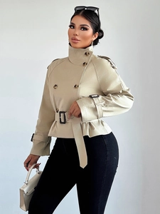 Detailed close-up of double-breasted beige trench coat with waist belt and military epaulets