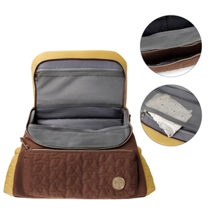 Internal view of the quilted diaper bag showing multi-compartment storage and mesh pockets