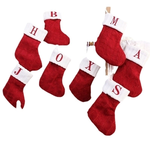 Red knitted Christmas stockings with white alphabet embroidery for holiday home decor
